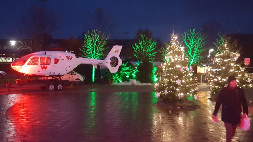 Beleuchteter Hubschrauber und Weihnachtsbäume bei einem Winter-Event